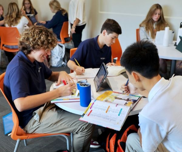 group of students sitting at academic support center tables working together