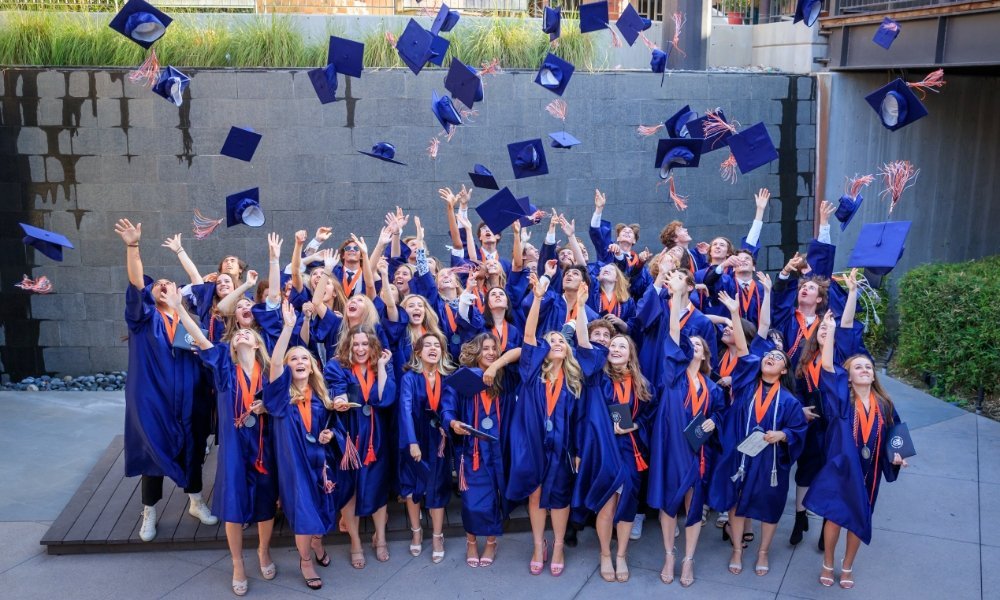 Pacifica graduates throwing their graduation caps
