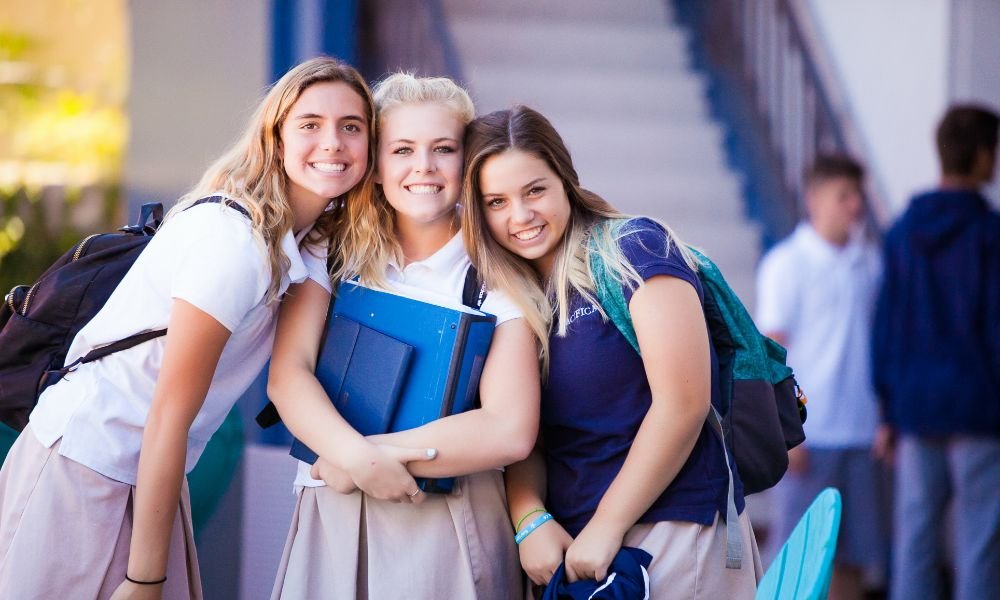 three Pacifica students posing together in the hallway